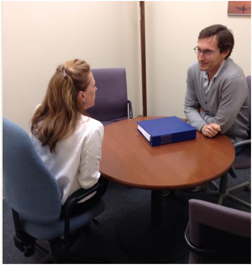 Settlement meeting. Two people are sitting at the same table in a private room and discussing their case.